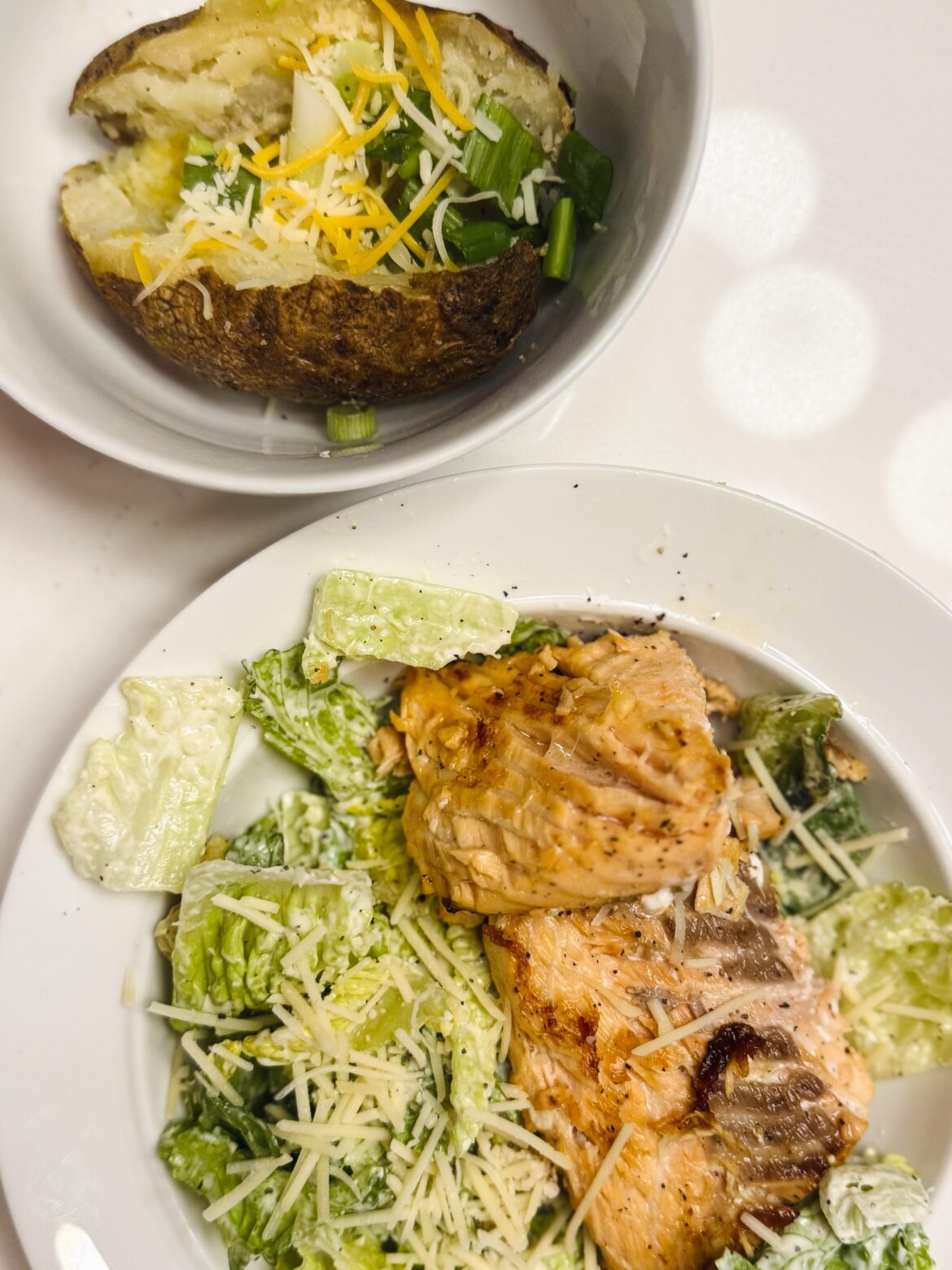 Salmon Caesar salad and a loaded baked potato