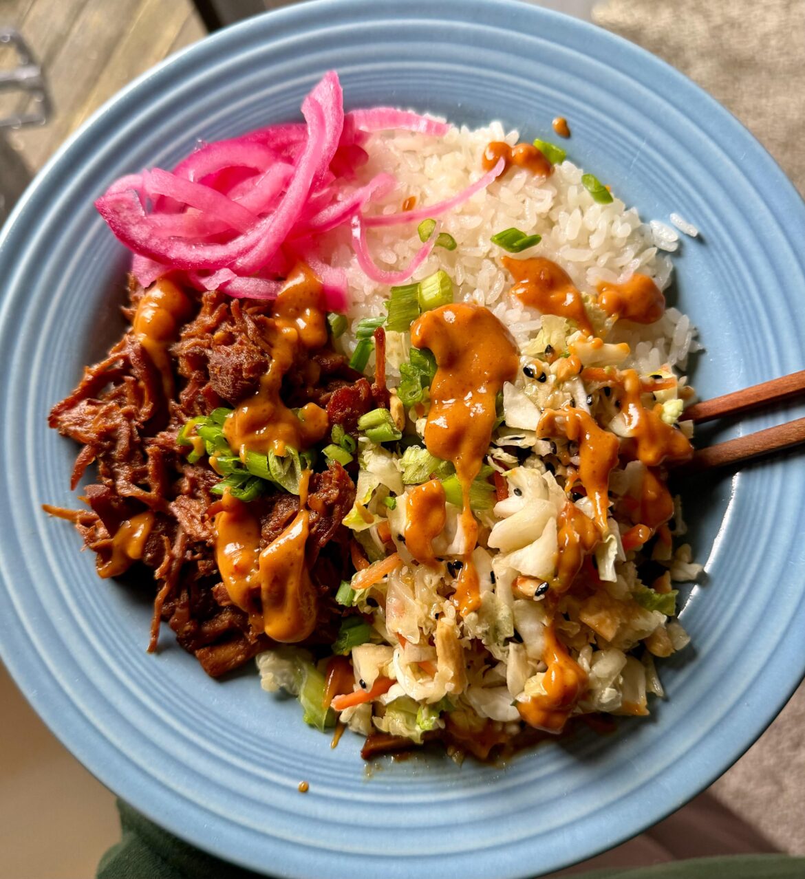 Honey-soy braised pork with orange & ginger, coconut rice, and slaw topped with peanut sauce