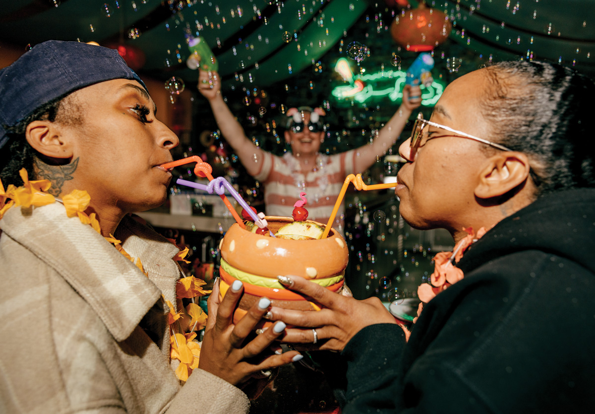 two people drink from straws and a hamburger shaped vessel