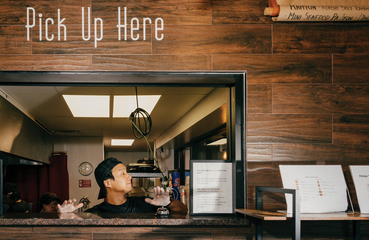 a man waits at a takeout window with the words 