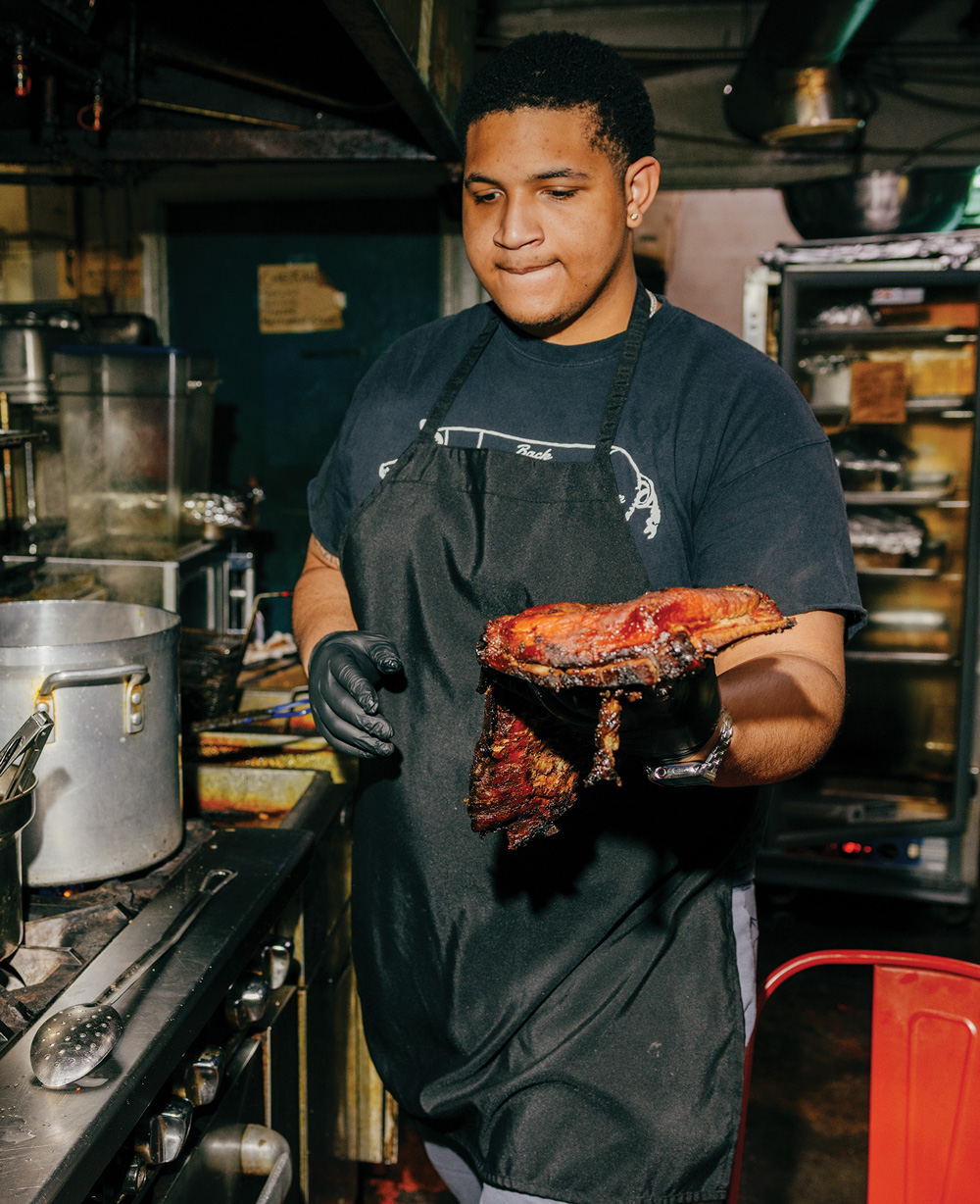 a chef holds a rack of bbq ribs at Daddy D’z BBQ Joynt