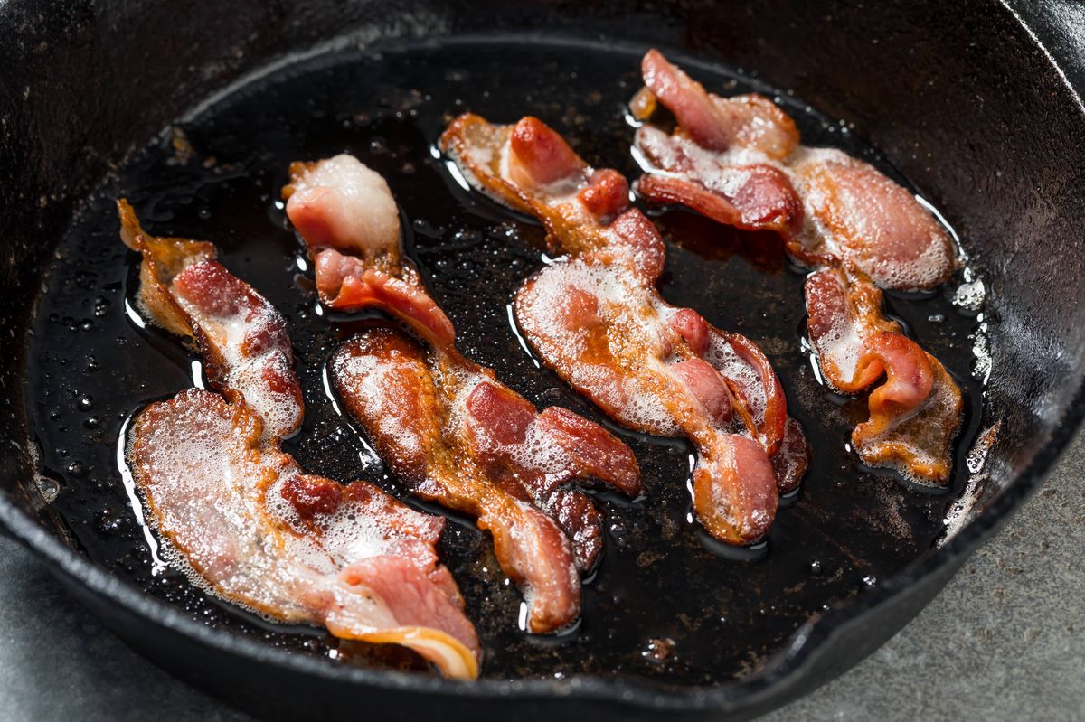 Greasy Fatty Cooked Crispy Bacon in a Skillet