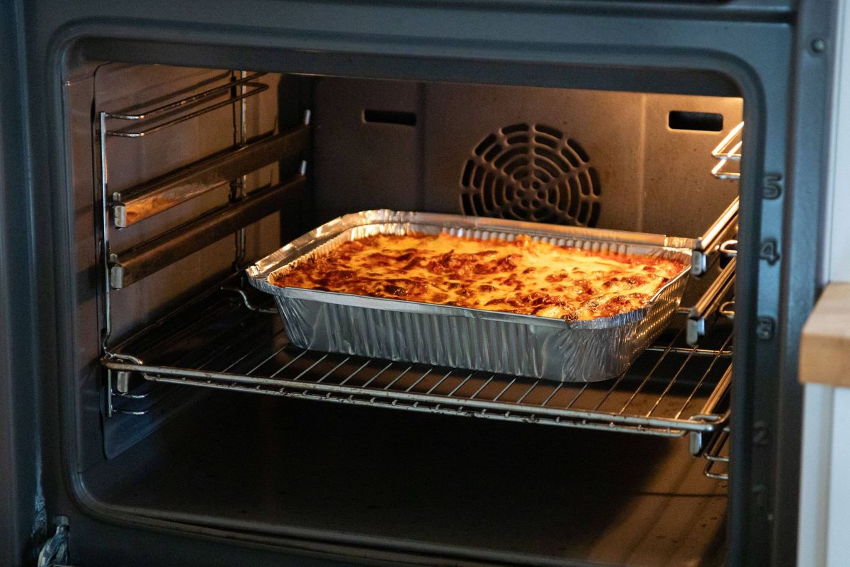 Lasagna baking in the oven with melted cheese and golden crust. Homemade Italian comfort food prepared for family dinner or festive meal