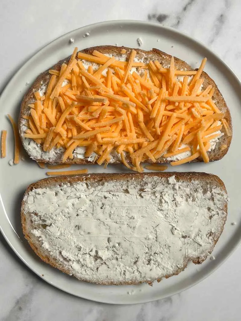 Shredded cheese on toasted bread with Boursin cheese.