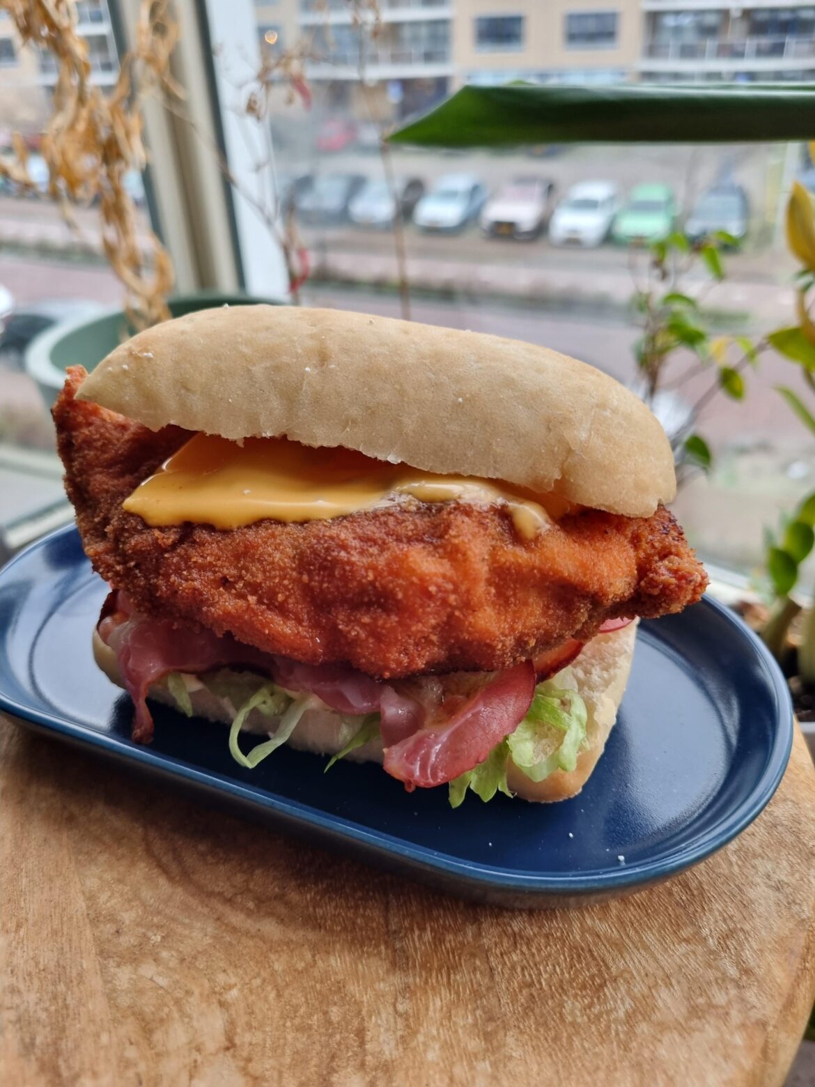 deep fried chicken schnitzel cheddar tomato lettuce mayo bbq sauce on a little ciabatta
