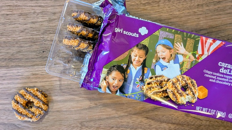 An open package of Caramel deLites with one cookie outside the package on a wood board
