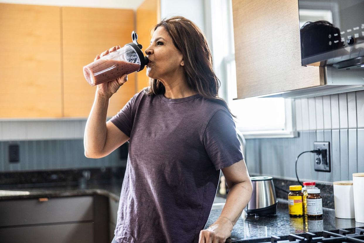 senior woman drinking a fruit smoothie at home