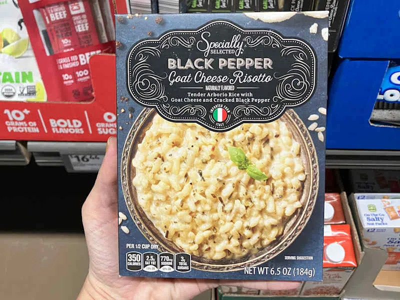 Someone holding black pepper and goat cheese risotto.