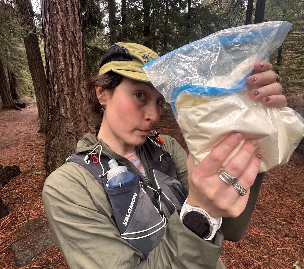 A woman in running gear holds up a bag of a pale yellow liquid