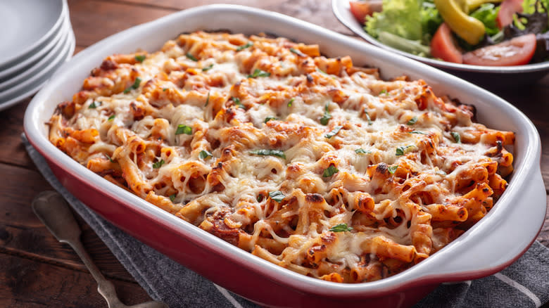 baked ziti in a casserole pan with melted cheese