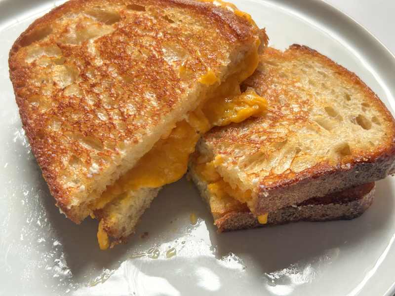 Sliced grilled cheese on plate.