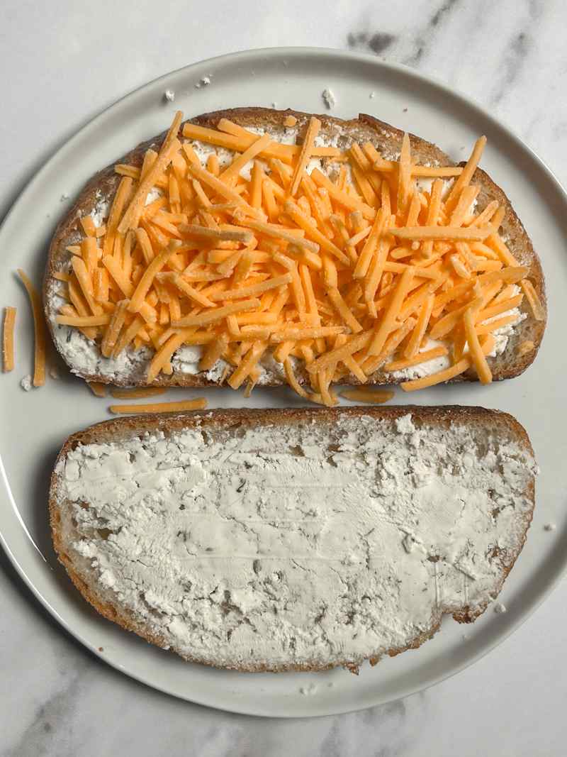 Shredded cheese on toasted bread with Boursin cheese.