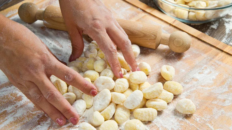 hands touching homemade fresh potato gnocchi