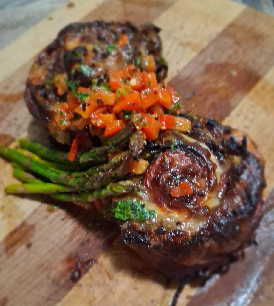 Skirt steak pinwheels stuffed with provolone cheese, caramelized onions, blue cheese, and baby spinach. Served with a side of lemon balsamic asparagus. Topped with a red chimichurri 😎