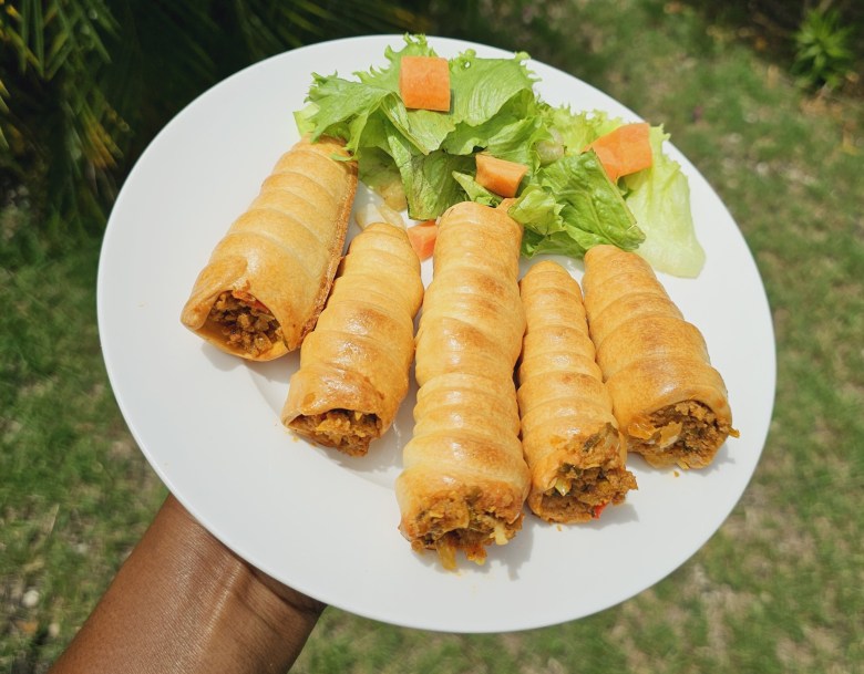 A plate of the Haitian delicacy cornet; a cone-shaped, flaky, buttery pastry filled with seasoned ground beef. Photo by Guethshina Altena/The Haitian Times.