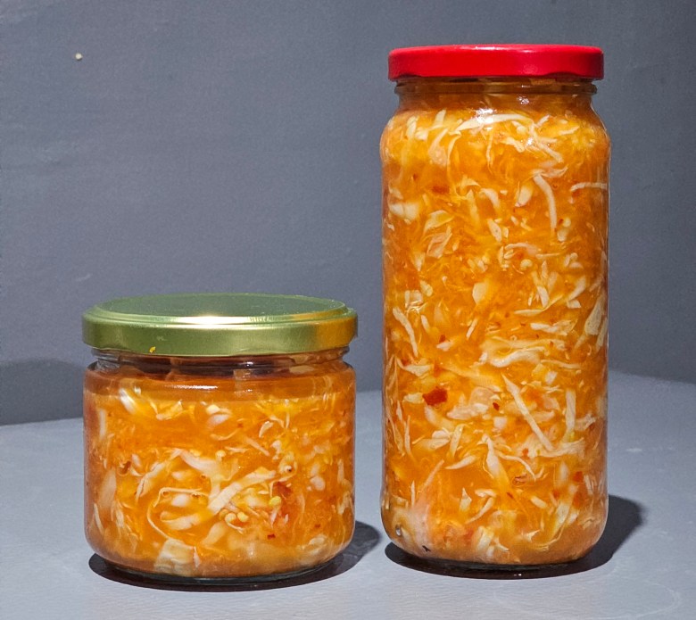 Two jars of traditional Haitian pikliz, typically made to be preserved and served as a side dish on many Haitian meals. Photo by Guethshina Altena/The Haitian Times.
