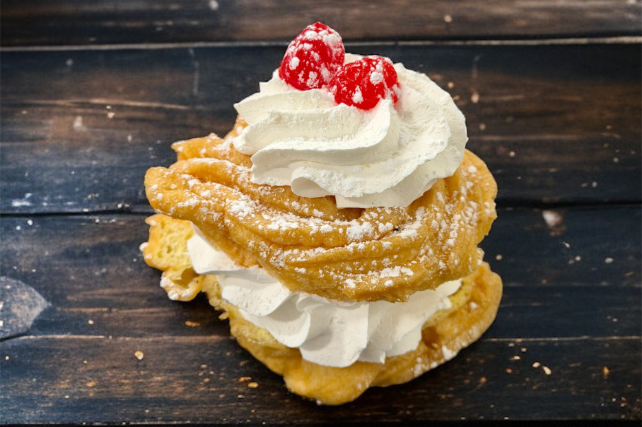 Zeppole finished with powdered sugar and cherries. 