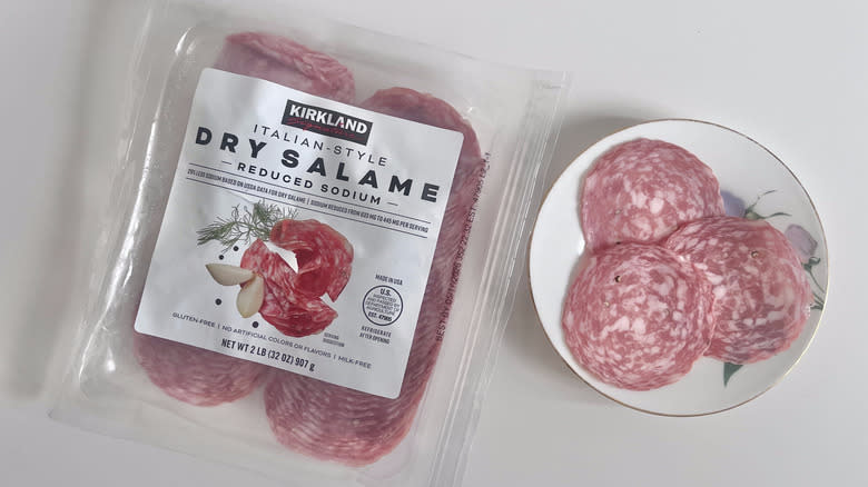 Pieces of Kirkland Signature Italian style dry salame on a plate with a packet of salame on the side