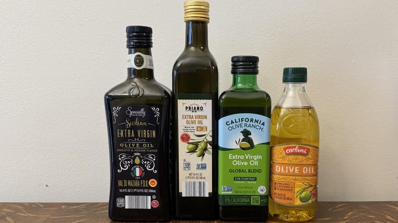 Four different kinds of olive oil against white background