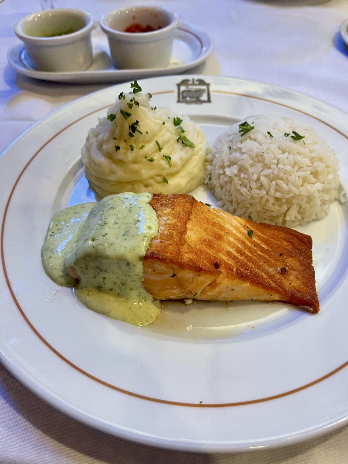 Nice seared salmon with herb cream sauce, mashed potatoes, and rice