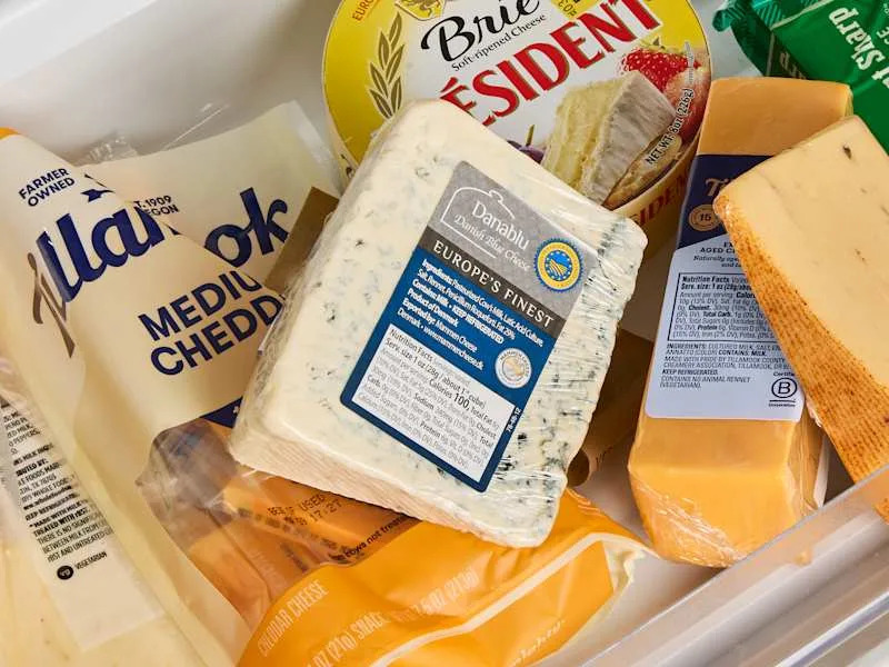 assorted cheeses in a drawer in the fridge