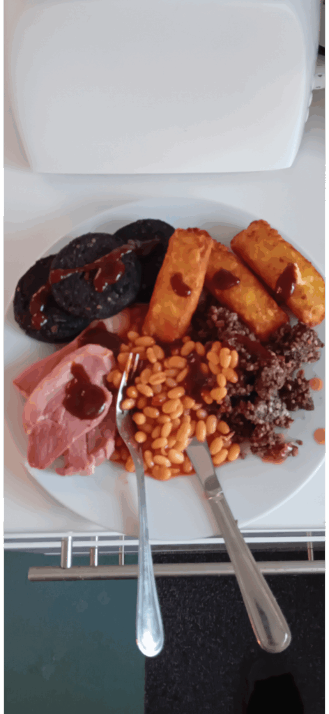 Cheesy hash browns, black pudding, gammon, beans and haggis, that i was able to microwave for just a few minutes after cutting it up and covering it in cling film, and a smokey bbq sauce! 😋😋😋😋😋