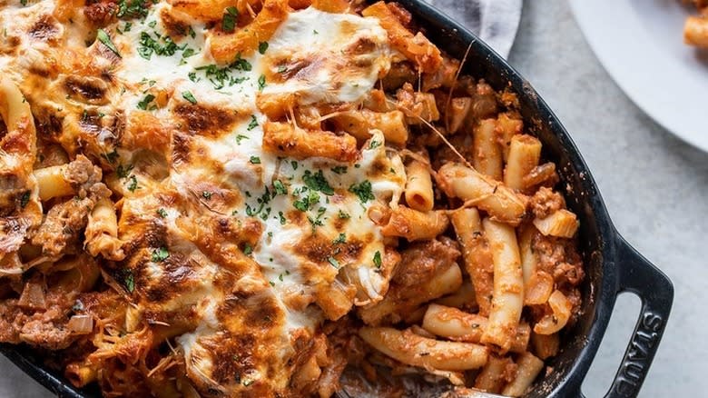 Cheesy baked ziti in black casserole dish