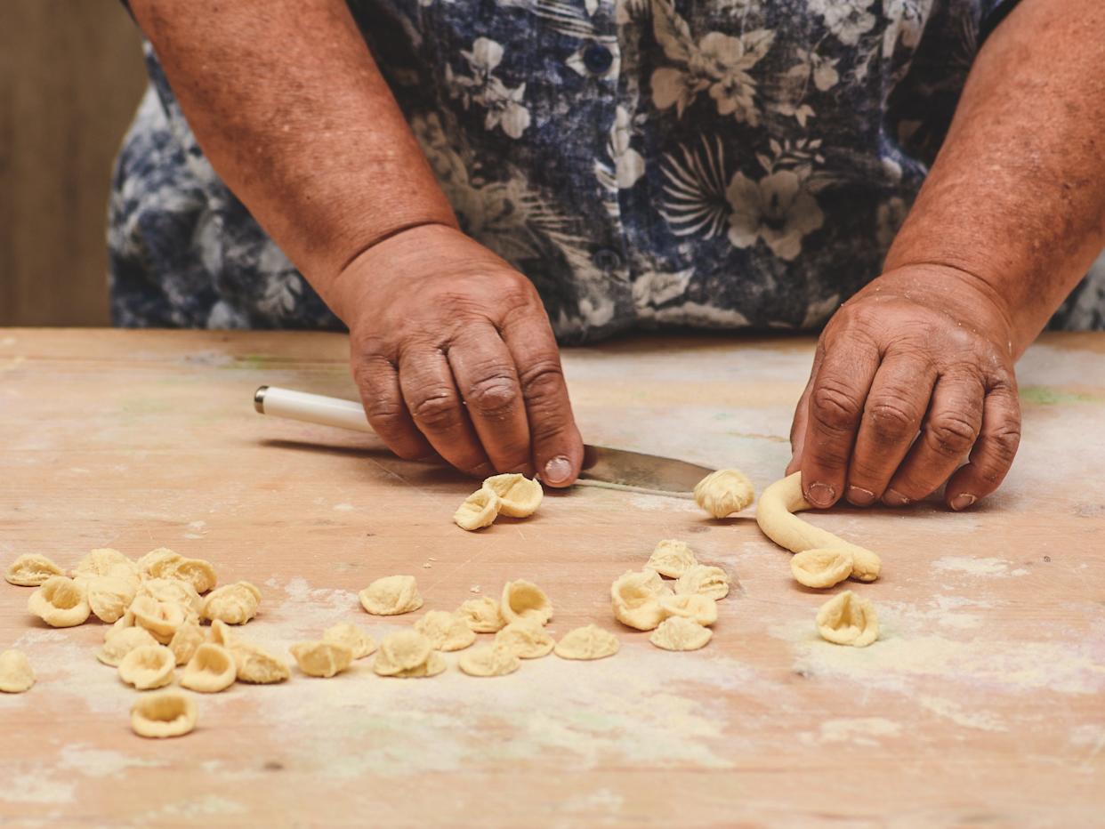 A close-up of a woman's hands making orecchiette in Old Town Bari.