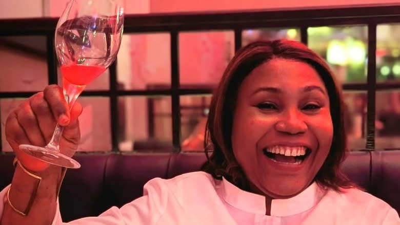 Michelin Star chef Adejoké Bakare smiling with glass of wine