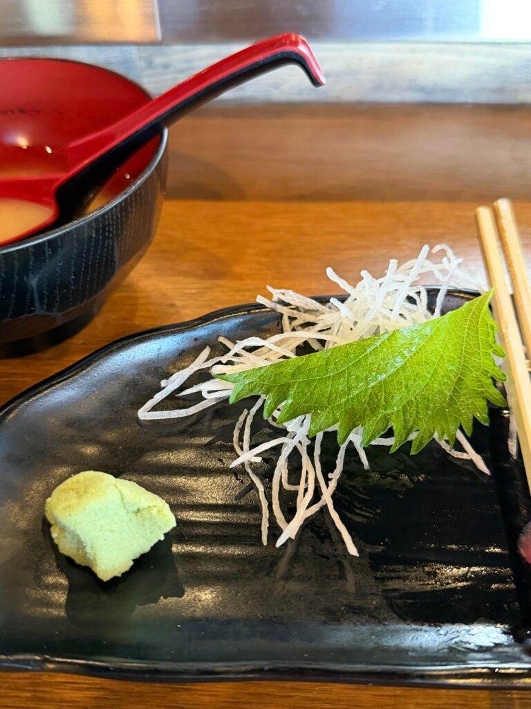 The shredded white stuff and the green leaf, are we supposed to eat it? It’s a great way to keep my sashimi from sticking to the plate, but I’m never sure if it’s just garnish/functional or if we eat it too?