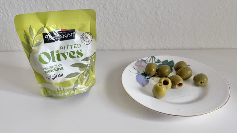 Tuscanini pitted olives package with some olives on a plate