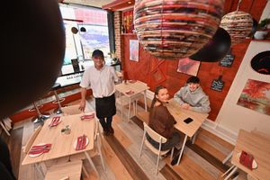 Antonio Leandro serves customers Liam Berry and Lilly Ferriday 