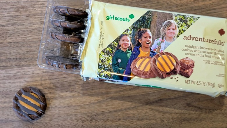An open package of Adventurefuls cookies and one cookie outside of the package on a wood board