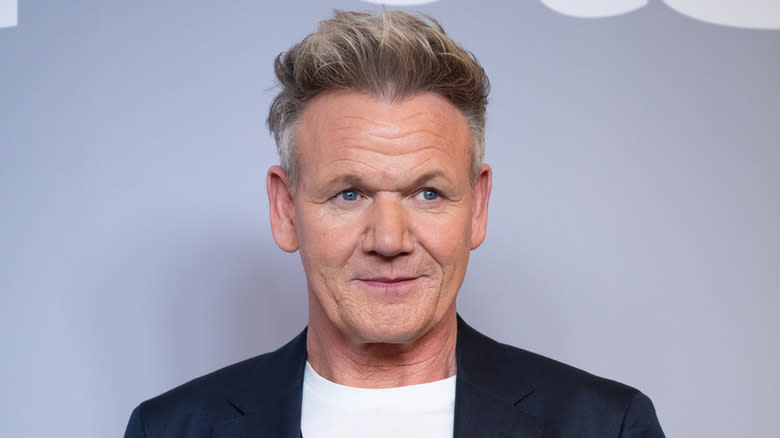 Gordon Ramsay wearing a suit jacket and t-shirt on the red carpet.