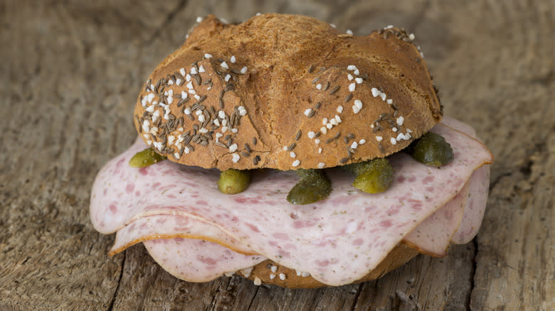 A sandwich featuring pickles and Leberkäse.