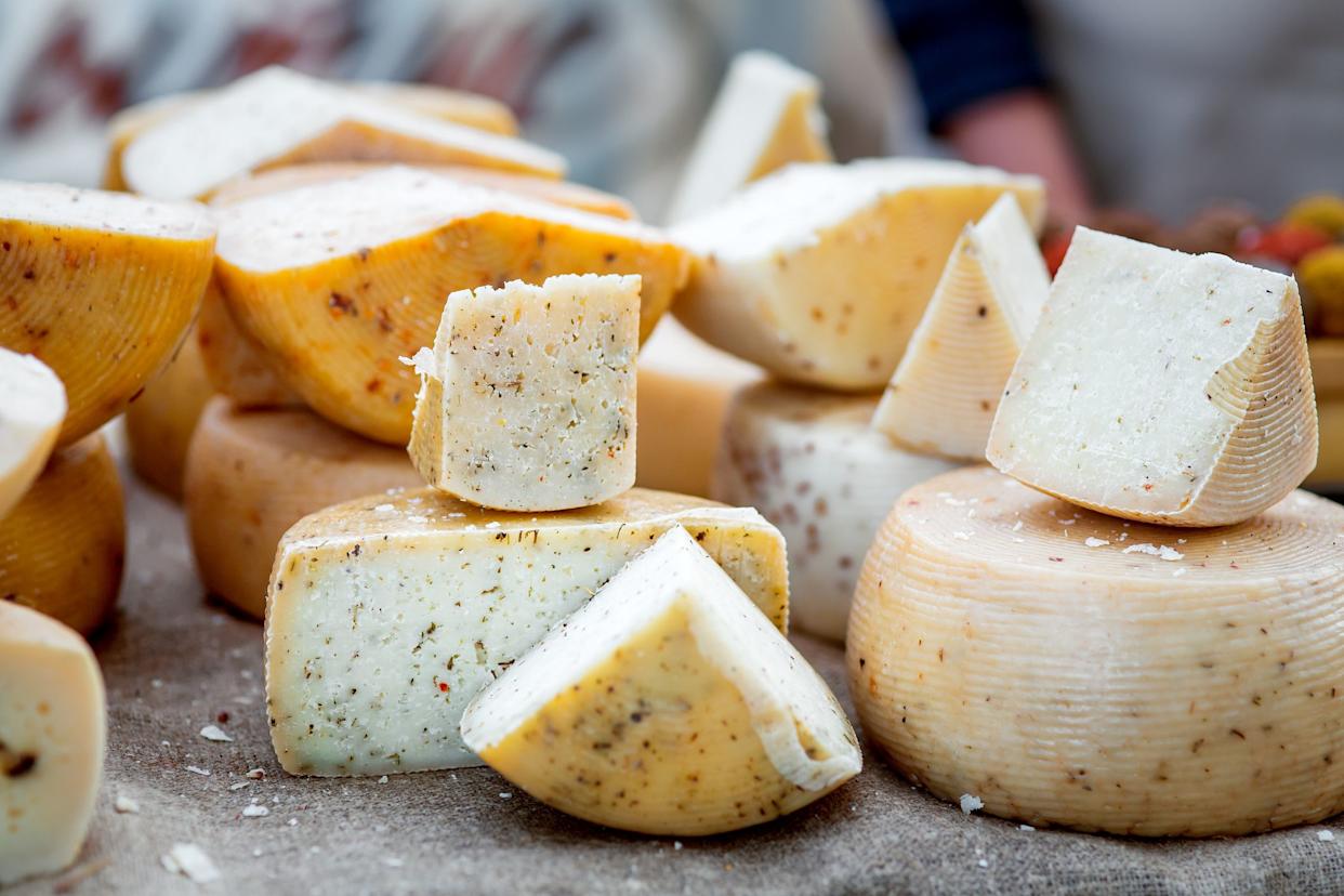 Hard varieties of goat cheese with spices close-up on the table.