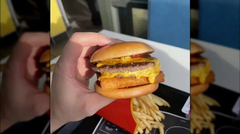 A hand holding a McDonald's surf and turf burger