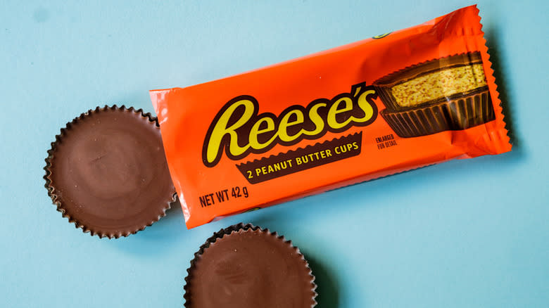 An open package of Reese's Peanut Butter Cups on a blue tabletop.
