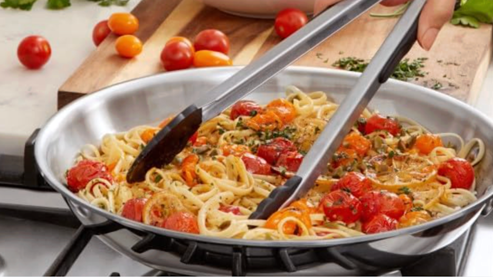 A person is shown scooping spaghetti with tongs for Yahoo's guide to how to make the best spaghetti