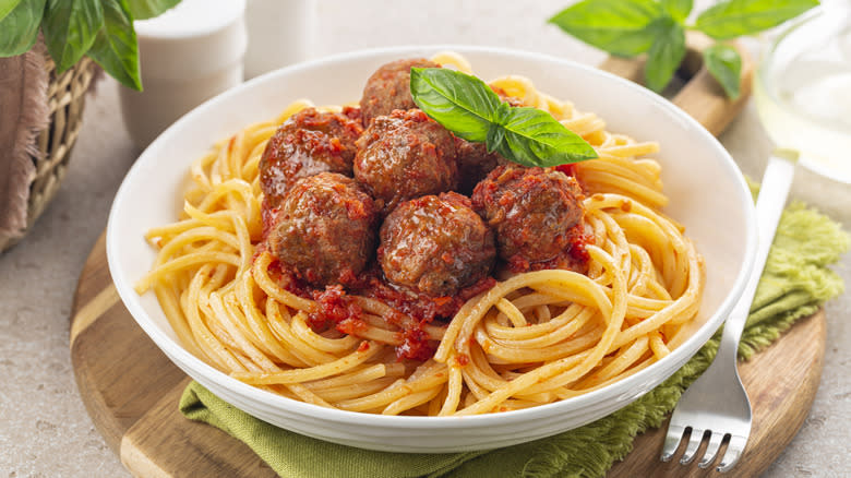 Spaghetti, meatballs, and tomato sauce in a white bowl