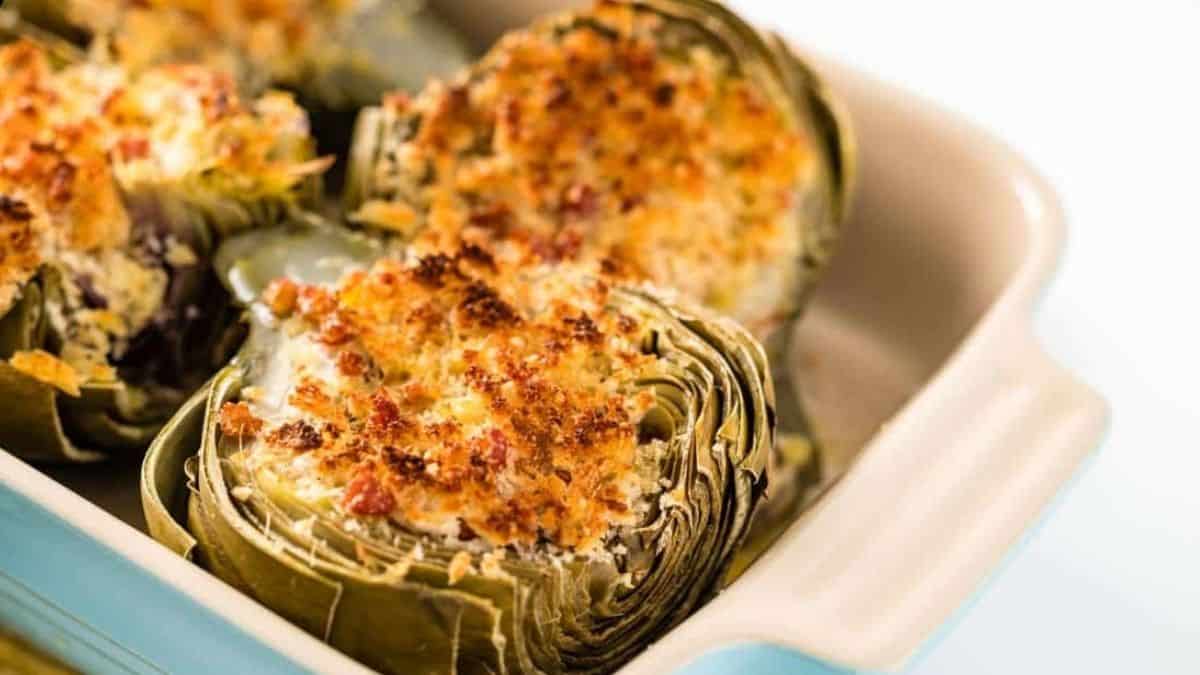 A close-up shot of Italian Stuffed Artichokes on a baking dish.