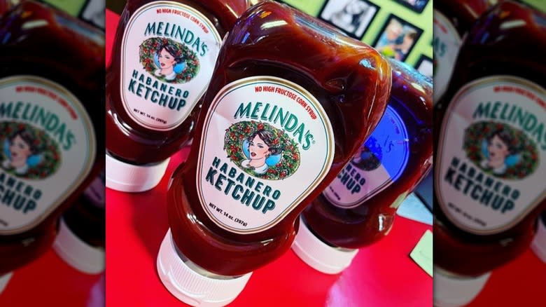 Tilted shot of a bottle of Melinda's Habanero Ketchup with another two behind it