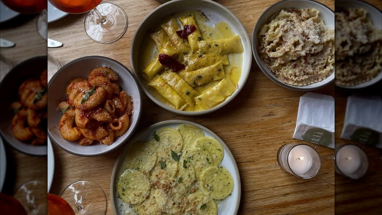 aerial view of wooden table at Lilia Italian restaurant in new york, with four pasta plates