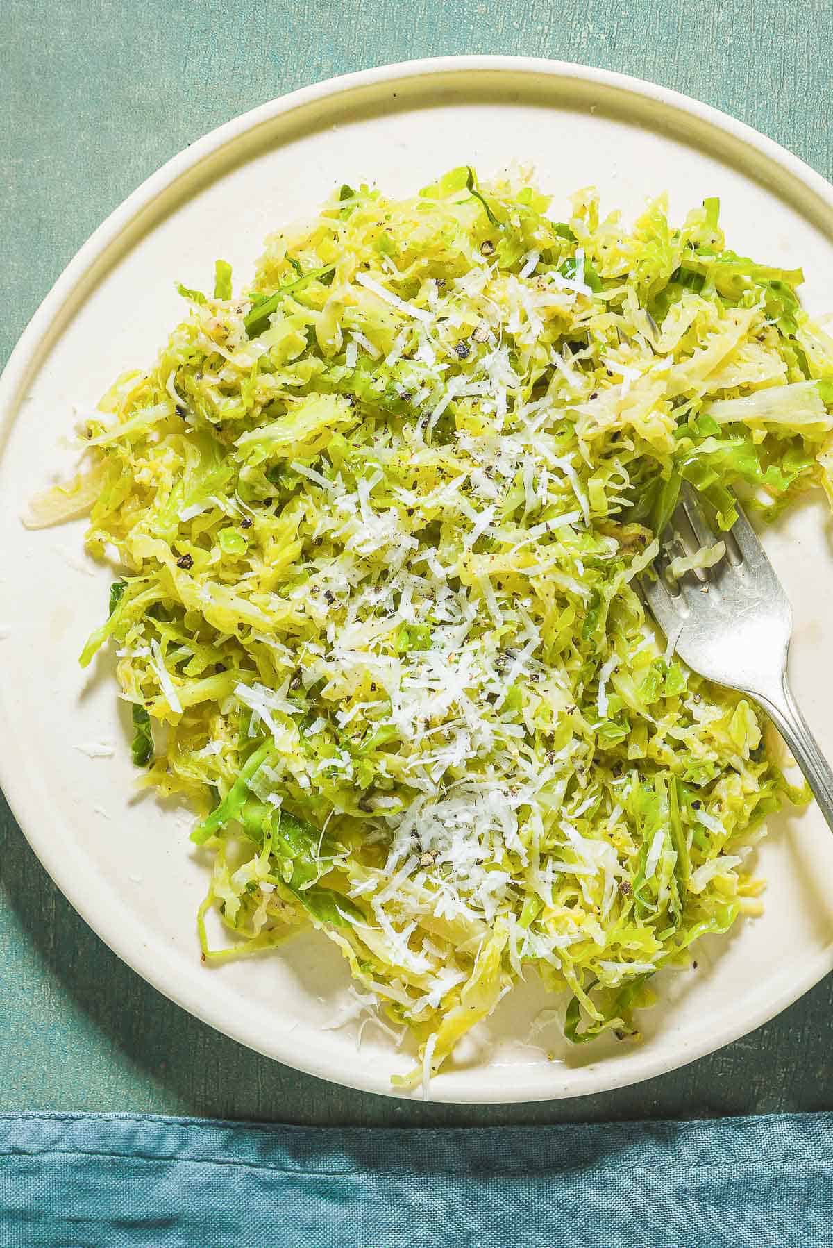 Cacio e pepe cabbage on a plate with a fork.