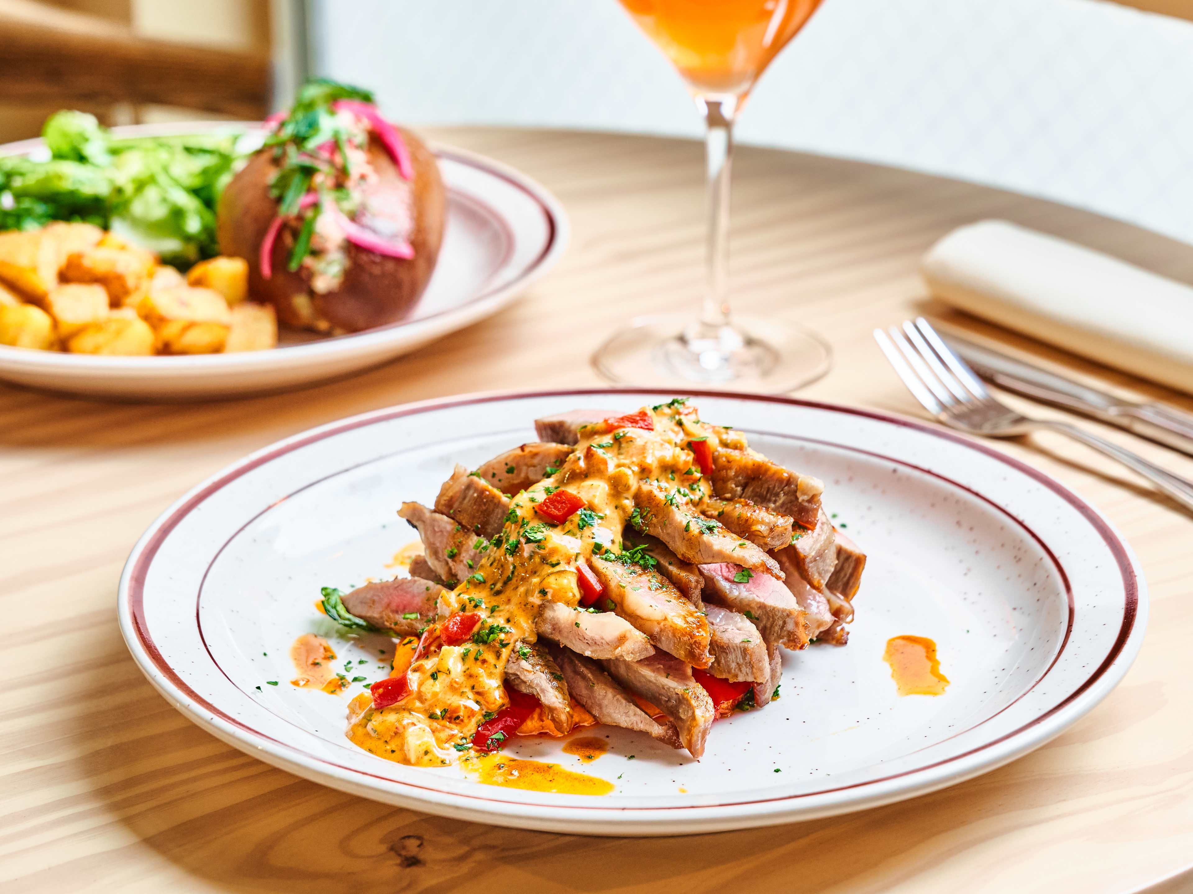 iberico pork sliced on a plate with sauce and peppers