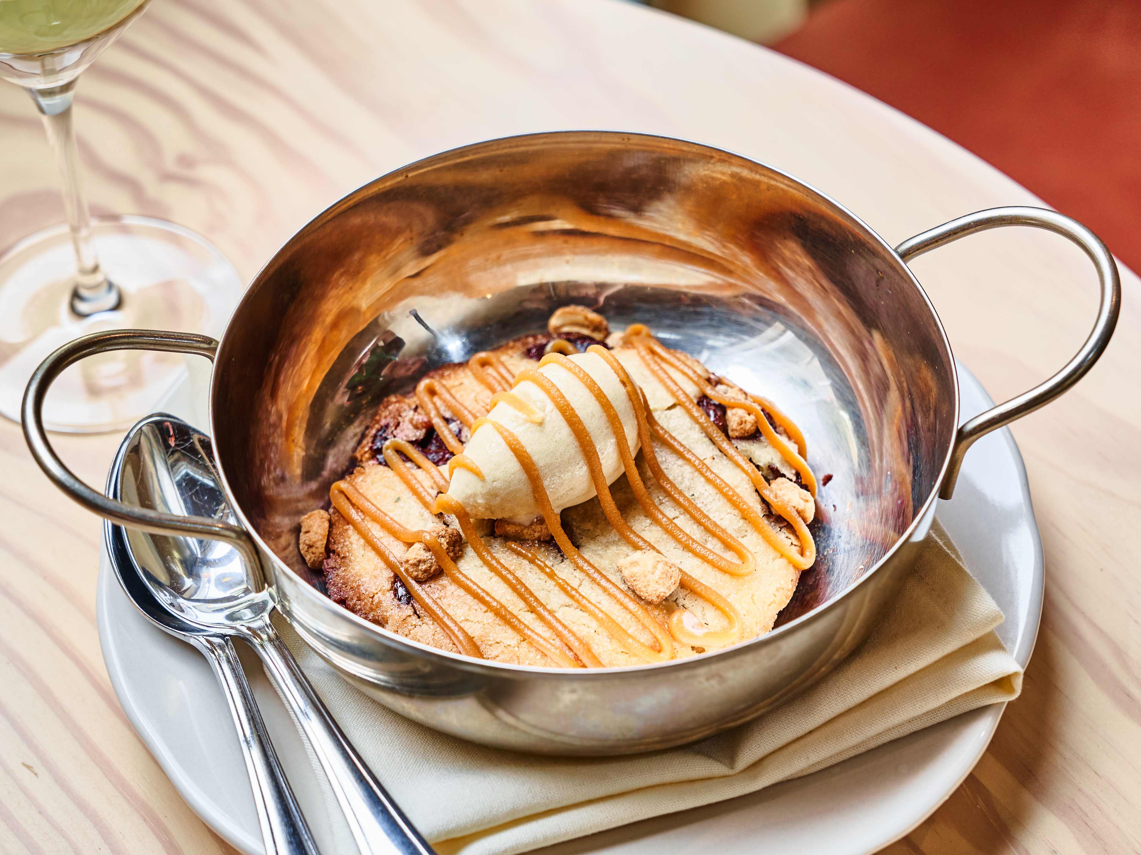 warm cookie in metal pot with ice cream and sauce
