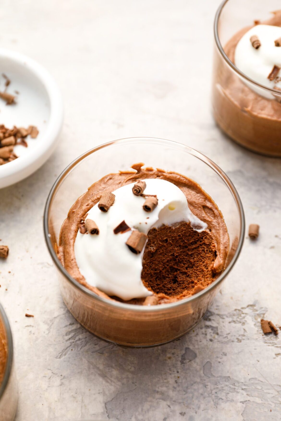 small glass with chocolate mousse topped with whipped cream and chocolate shavings