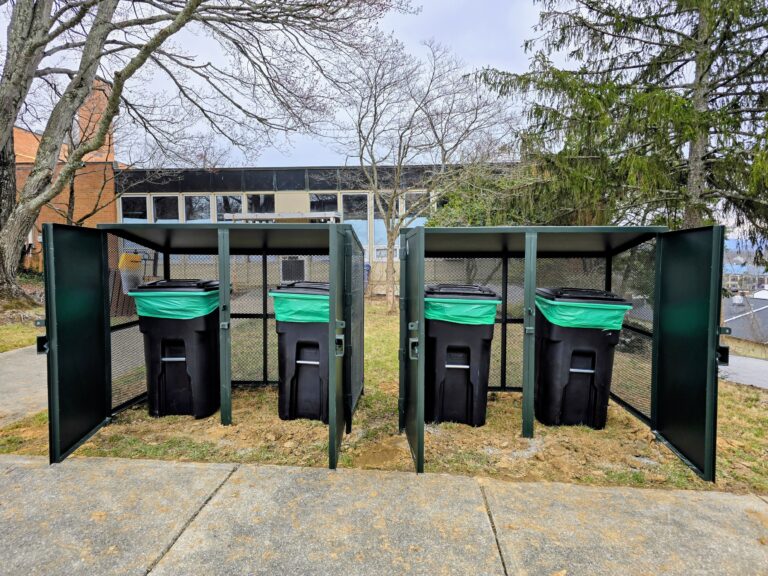 Four food scrap bins inside of a wildlife proof "bearicade" at the North Asheville Community Center.