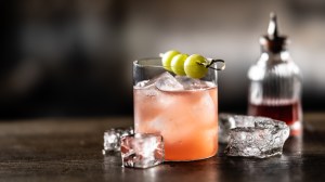 Enzoni cocktail on a bar with grape garnish