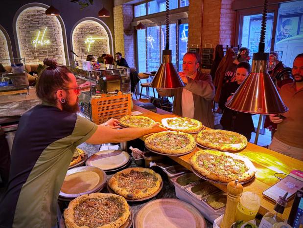 Laszlo Bardossy, head chef of the Neverland Pizzeria serves the restaurant's Roman-era pizza in Budapest, Hungary, on Feb. 11, 2026. (AP Photo/Bela Szandelszky)